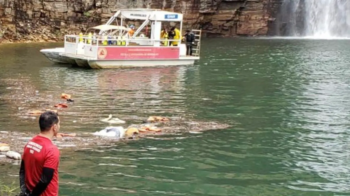 Mann steht mit Rettungsweste vor Felswand, Taucher suchen im See nach Leichen