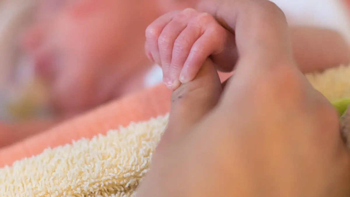 A mother holds the hand of her premature delivered son lying in an incubator in a room of the pediatric intensive care unit of the Braunschweig hospital in Braunschweig, Germany, 07 January 2014. The intensive care unit for children meanwhile exists for 35 years and thereby is the oldest intensive care unit for premature babies and children in Lower Saxony. Photo: Jochen Luebke