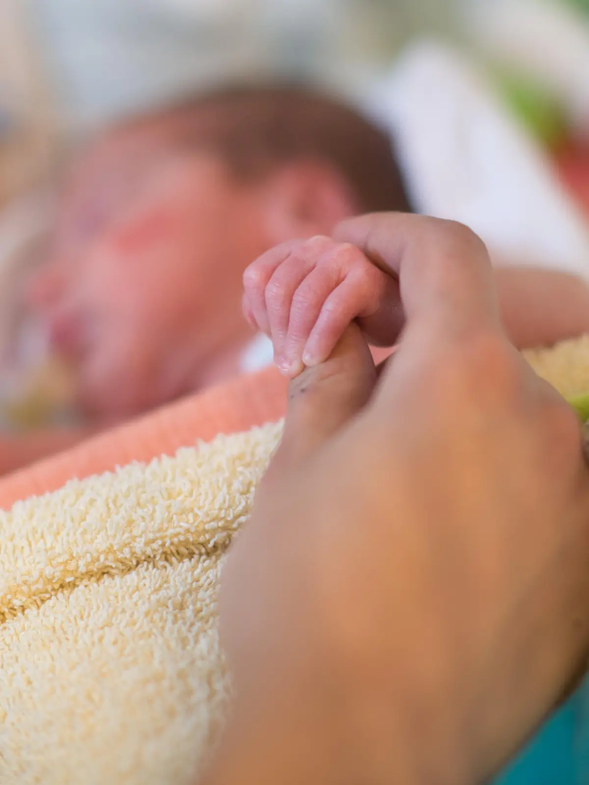 A mother holds the hand of her premature delivered son lying in an incubator in a room of the pediatric intensive care unit of the  Braunschweig hospital in Braunschweig, Germany, 07 January 2014. The intensive care unit for children meanwhile exists for 35 years and thereby is the oldest intensive care unit for premature babies and children in Lower Saxony. Photo: Jochen Luebke