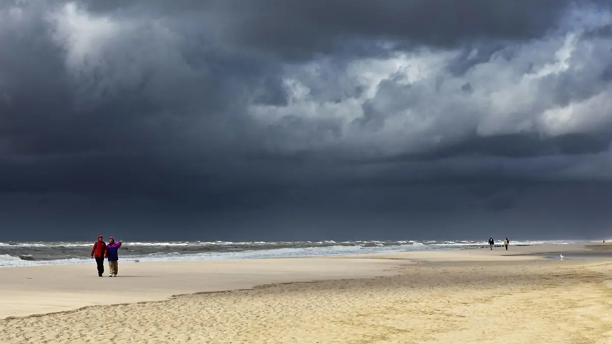 dunkle Regenwolken ueber Spaziergaenger am Sandstrand, Deutschland, Schleswig-Holstein, Sylt | dark rain clouds over pedestrians on sandy beach, Germany, Schleswig-Holstein, Sylt