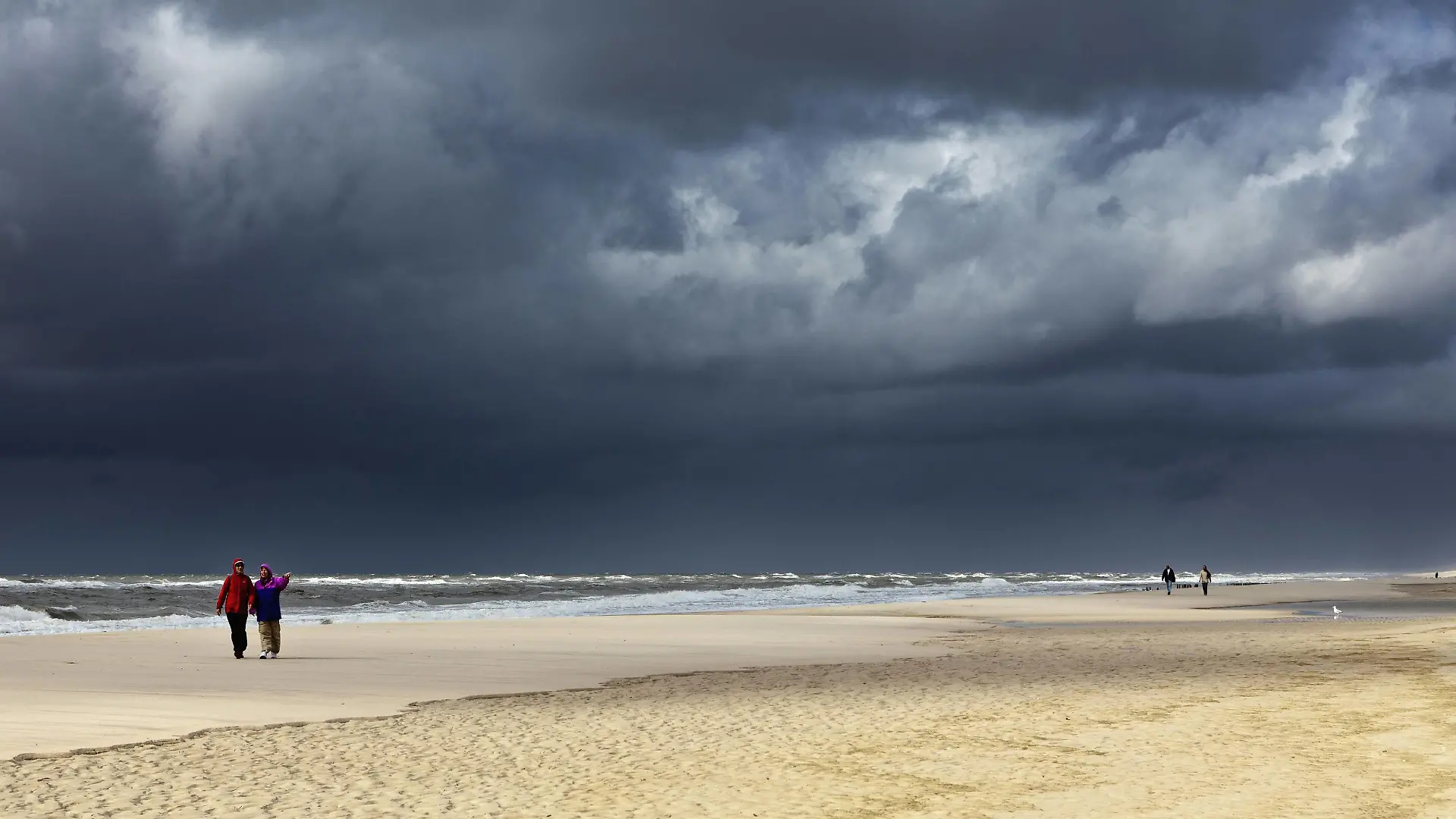 dunkle Regenwolken ueber Spaziergaenger am Sandstrand, Deutschland, Schleswig-Holstein, Sylt | dark rain clouds over pedestrians on sandy beach, Germany, Schleswig-Holstein, Sylt
