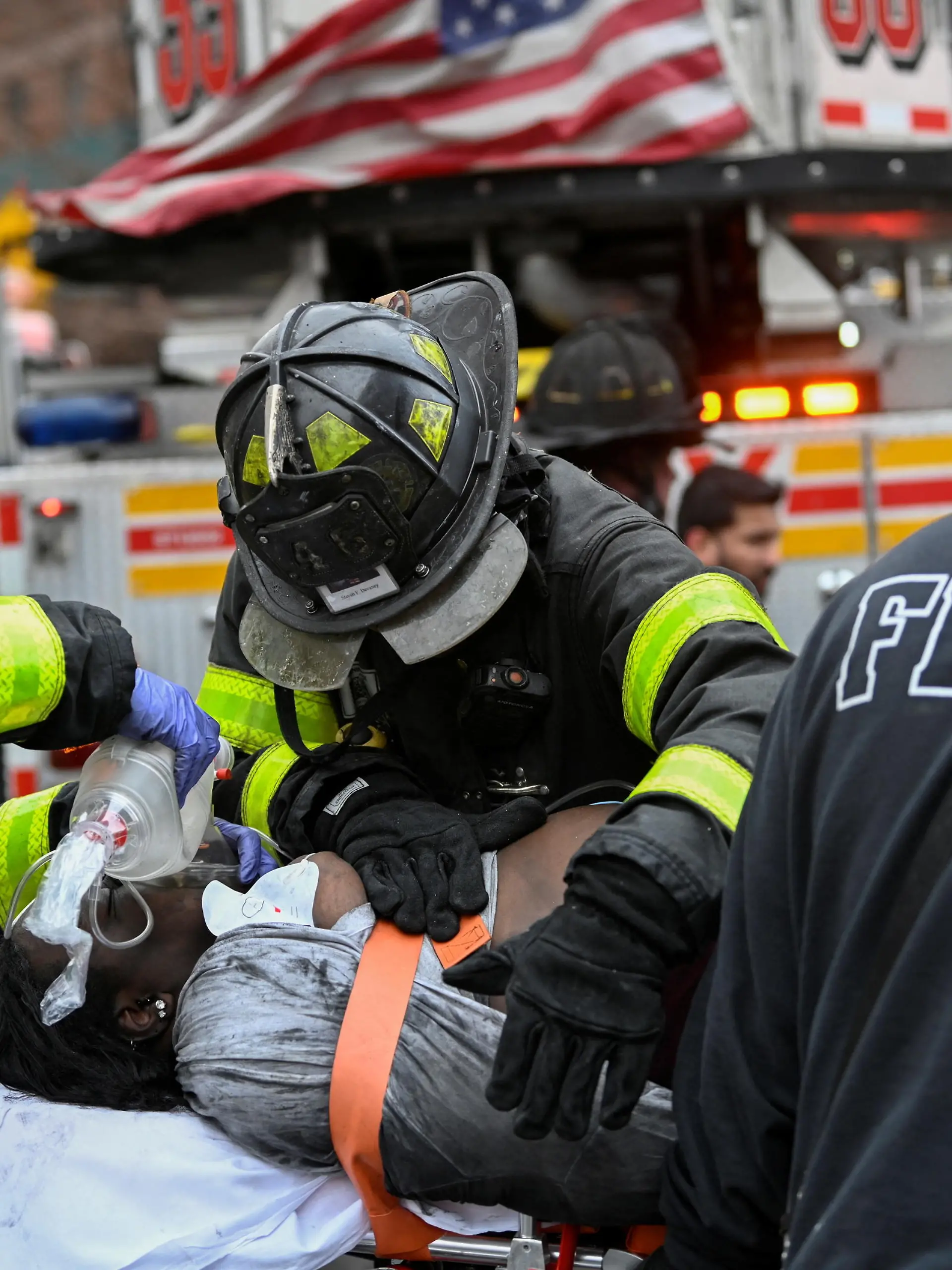 Emergency personnel from the FDNY provide medical aid as they respond to an apartment building fire in the Bronx borough of New York City, U.S., January 9, 2022.  REUTERS/Lloyd Mitchell