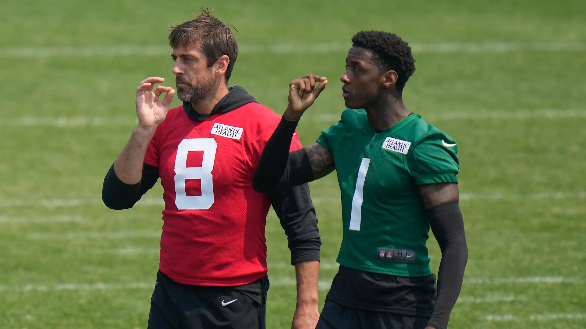 New York Jets Aaron Rodgers, left, and Sauce Gardner pretend to smoke as they greet one another at the NFL football team's training facility in Florham Park, N.J., Tuesday, June 6, 2023. (AP Photo/Seth Wenig)