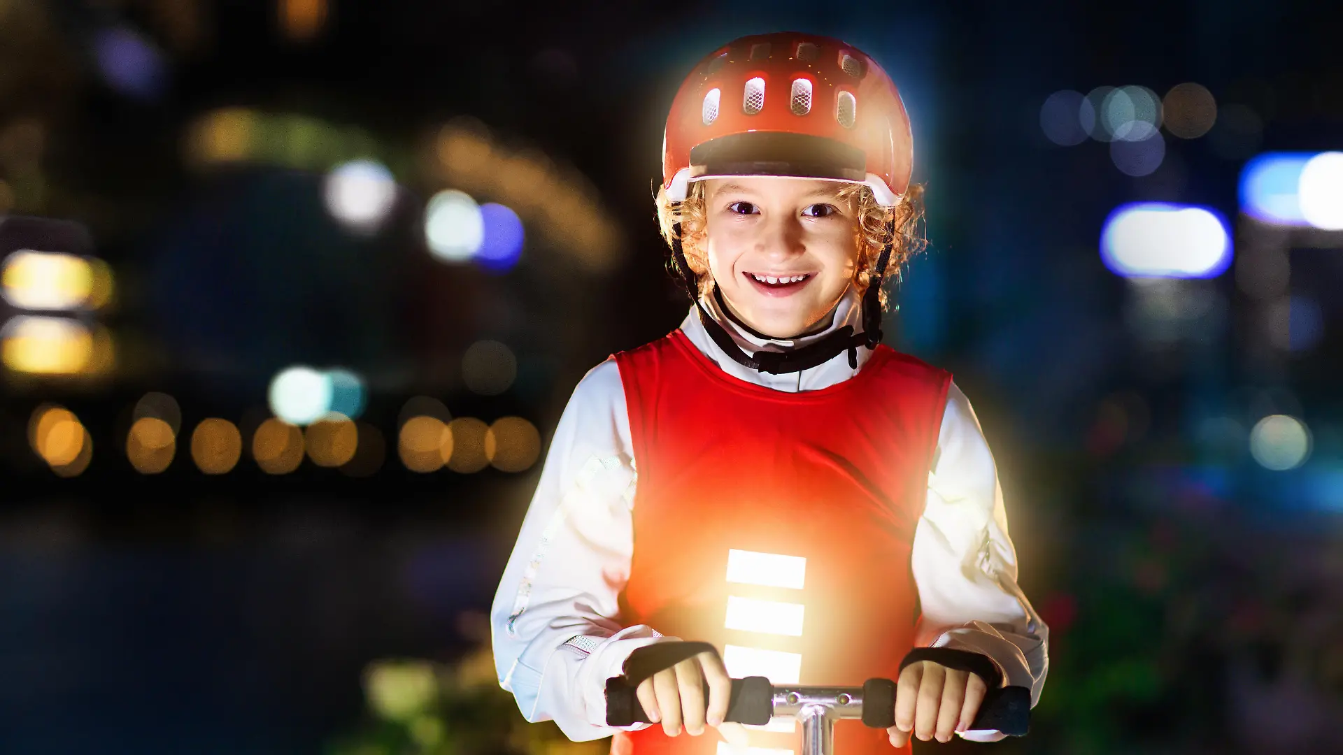 Kid in reflective vest in darkness. Safety on dark city streets for school children. Safe way home at night or in the evening. Fluorescent stripes on kids clothing and backpack. Boy walking at dusk.