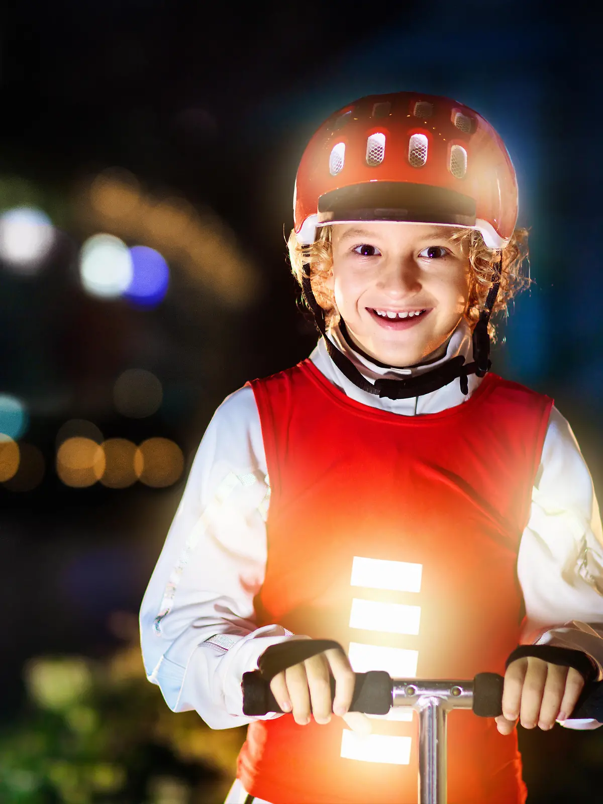 Kid in reflective vest in darkness. Safety on dark city streets for school children. Safe way home at night or in the evening. Fluorescent stripes on kids clothing and backpack. Boy walking at dusk.