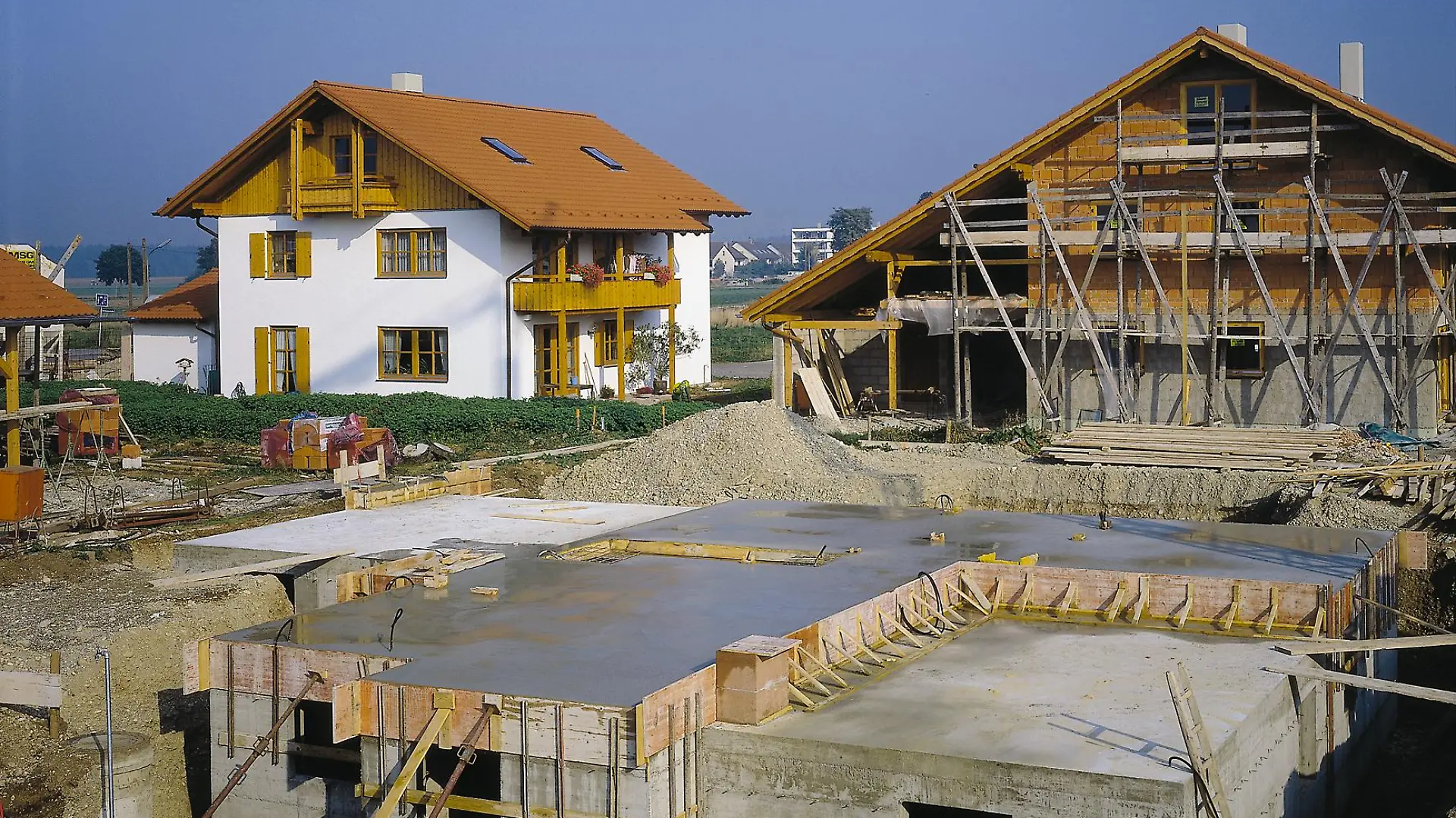 Eine Baustelle mit mehreren Häusern in verschiedenen Bauphasen.
