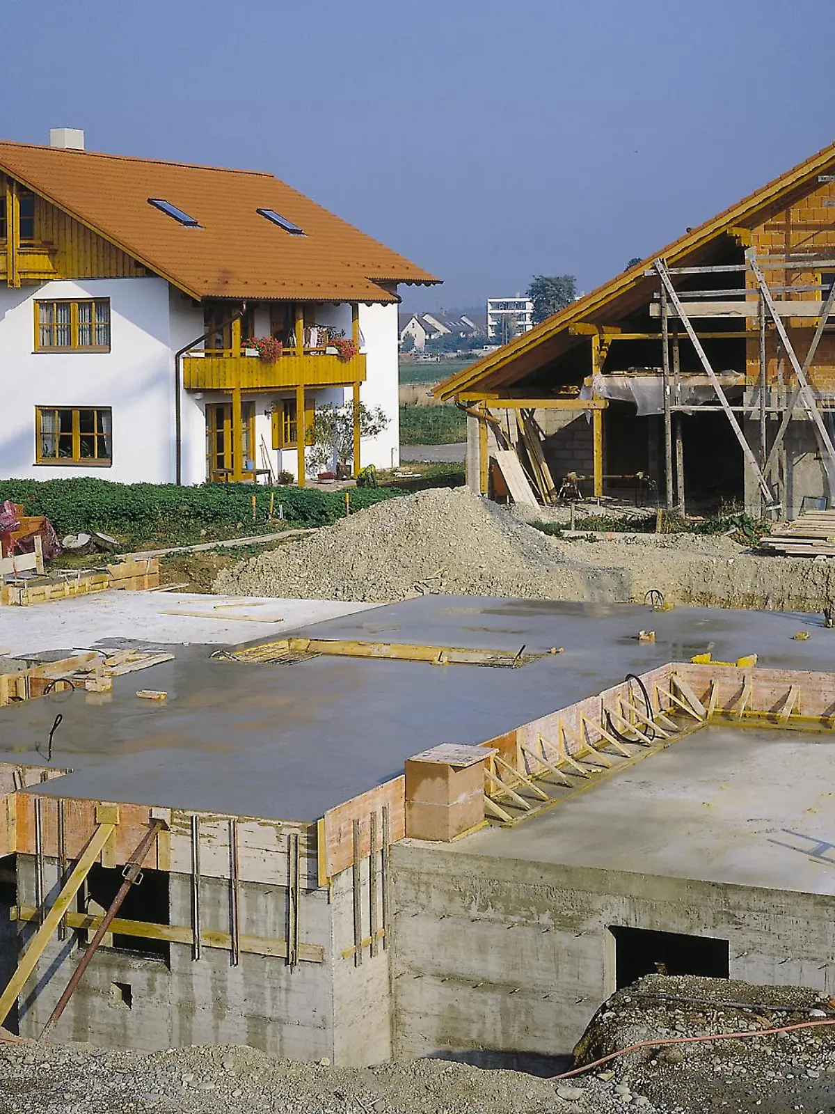 Eine Baustelle mit mehreren Häusern in verschiedenen Bauphasen. 
