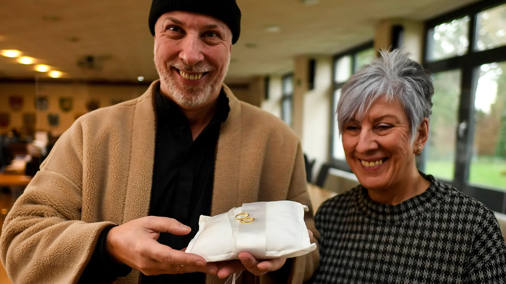 07.01.2022, Nordrhein-Westfalen, Swisttal: Die Geschwister Frank Johannes Knepper (l) und Rita Knepper halten die Eheringe ihrer Eltern in der Hand, die sie heute überreicht bekommen haben. Bei der Flut im letzten Jahr wurden die Ringe vom Hochwasser mitgerissen, sie wurden erst kürzlich von einem Helfer im Schlamm gefunden. Nach kurzer Recherche, konnte die Gemeinde aufgrund der Gravuren feststellen, zu wem die Ringe gehören. Foto: Roberto Pfeil/dpa +++ dpa-Bildfunk +++