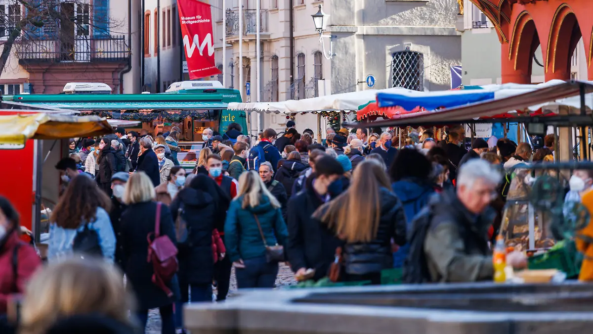 31.12.2021, Baden-Württemberg, Freiburg im Breisgau: Menschen gehen durch die Innenstadt. Trotz teils voller Innenstädte stimmt das Nach-Weihnachtsgeschäft den Einzelhandel nicht wirklich glücklich. «Es sind zwar viele Menschen auf der Straße, aber wenig Tüten», sagte die Hauptgeschäftsführerin des Handelsverbands Baden-Württemberg, Sabine Hagmann. Viele kämen nicht zum Einkaufen in die Städte. Erschwerend komme hinzu, dass Schülerausweise in den Ferien nicht als Corona-Testnachweise gelten. Foto: Philipp von Ditfurth/dpa +++ dpa-Bildfunk +++