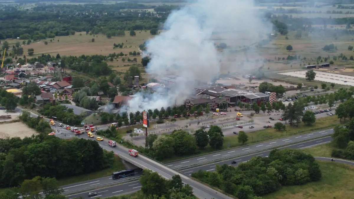06.06.2023, Brände;Brandenburg;Deutschland, Elstal: Rauch steigt auf dem Gelände des Freizeitparks Karls Erdbeerhof im brandenburgischen Elstal bei Wustermark. Bei dem Brand auf dem Gelände sind mehrere Menschen verletzt worden. Hauptsächlich handele es sich um Rauchgasvergiftungen, sagte ein Sprecher der Feuerwehr am Dienstag. (Aufnahme mit einer Drone) Foto: Christian Pörschmann/dpa +++ dpa-Bildfunk +++
