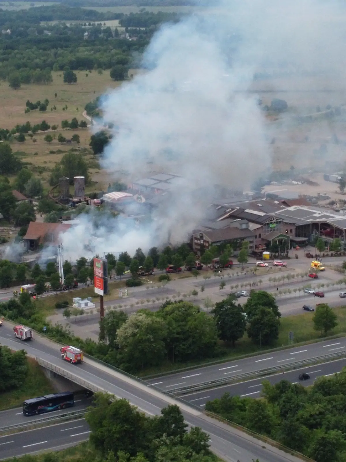 06.06.2023, Brände;Brandenburg;Deutschland, Elstal: Rauch steigt auf dem Gelände des Freizeitparks Karls Erdbeerhof im brandenburgischen Elstal bei Wustermark. Bei dem Brand auf dem Gelände sind mehrere Menschen verletzt worden. Hauptsächlich handele es sich um Rauchgasvergiftungen, sagte ein Sprecher der Feuerwehr am Dienstag. (Aufnahme mit einer Drone) Foto: Christian Pörschmann/dpa +++ dpa-Bildfunk +++