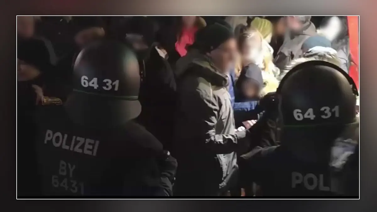 Vater mit seinem Sohn inmitten Demonstrierender und Polizisten in München