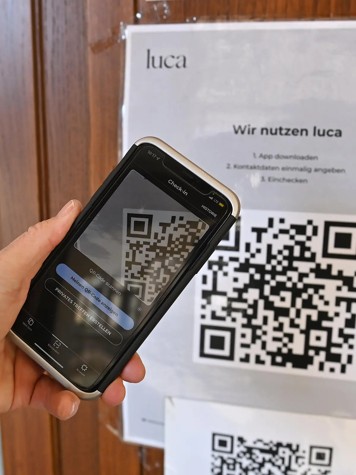 Einchecken mit der Luca App. Hinweisschild mit Informationen zur Schnellregistrierung mit der LUCA App an der Eingangstuer an einem Restaurant,