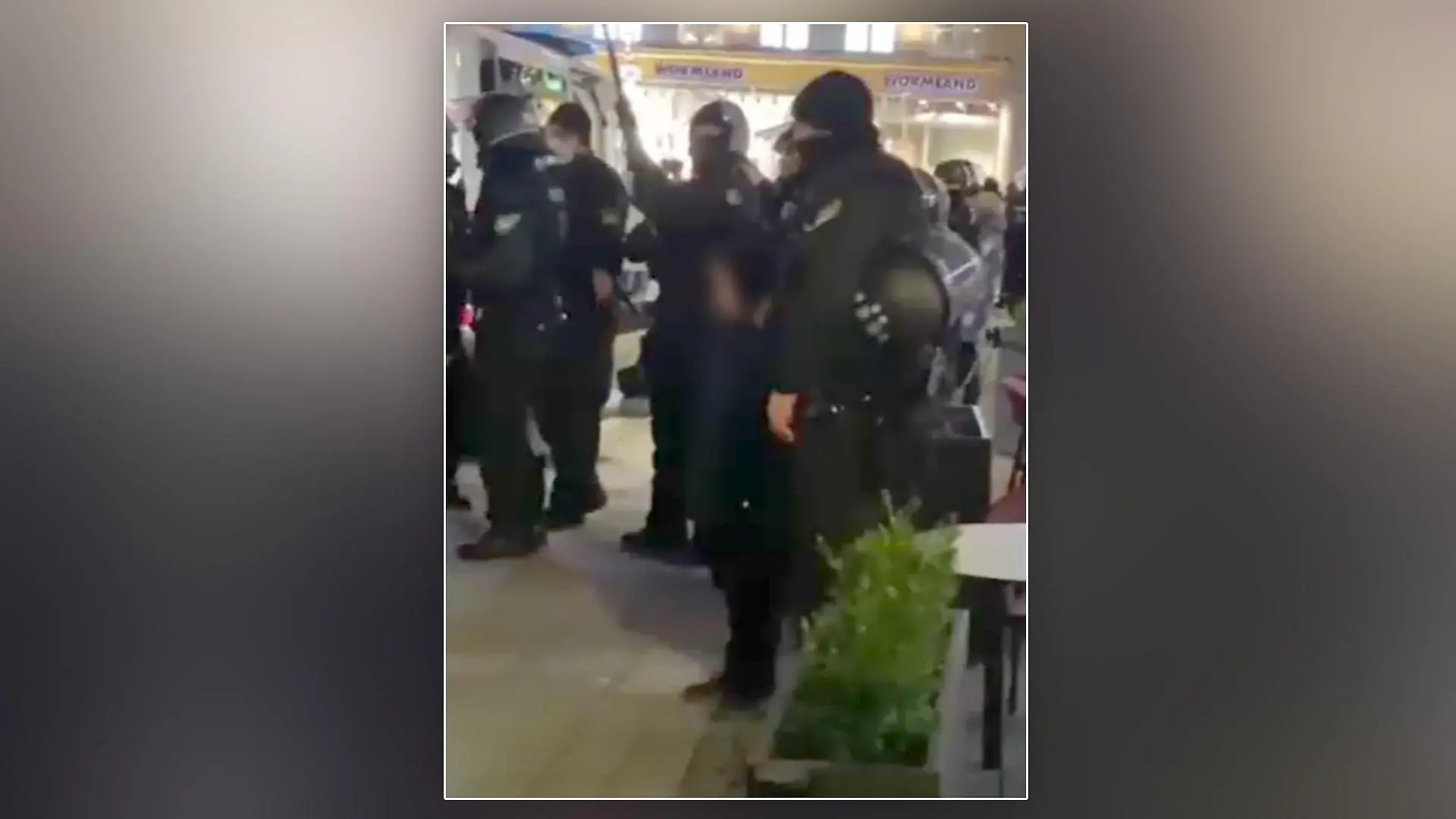 Ein kleiner Junge steht inmitten von Polizeibeamten auf einer Corona-Demo in München.