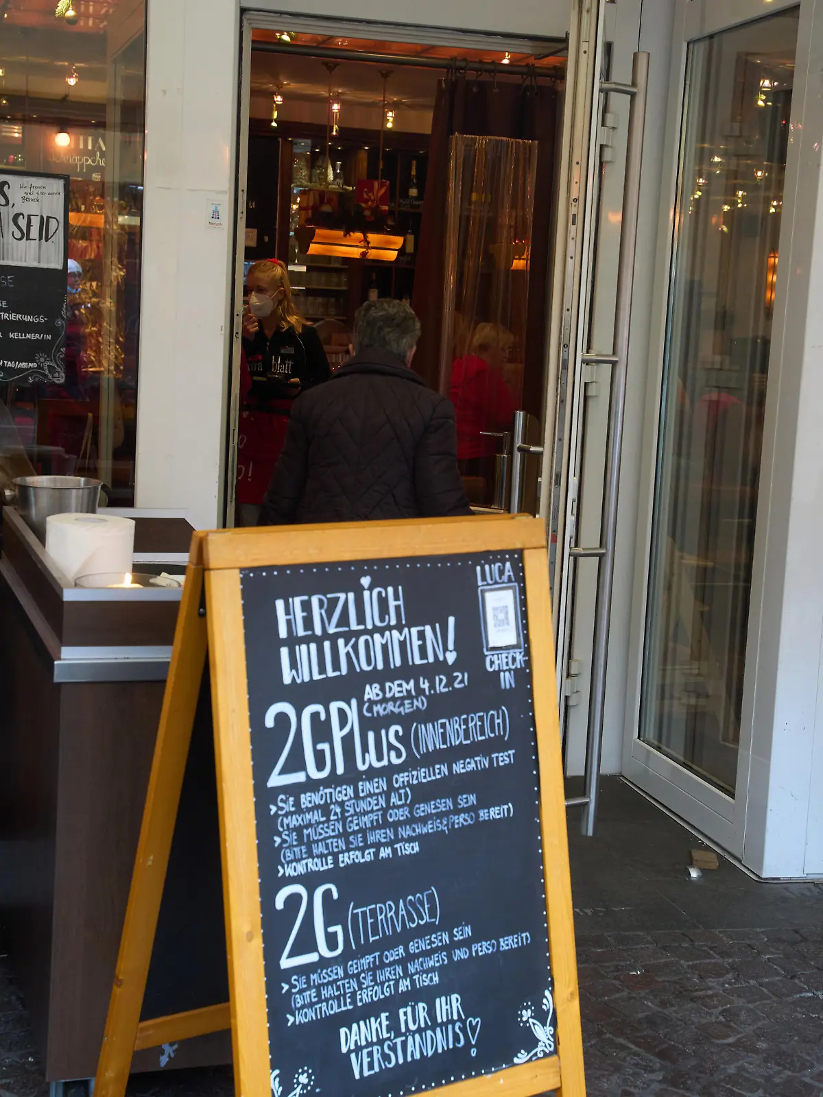 Ein Schild vor einem Lokal weist auf die ab Samstag geltende 2Gplus-Regelung im Innenraum hin.