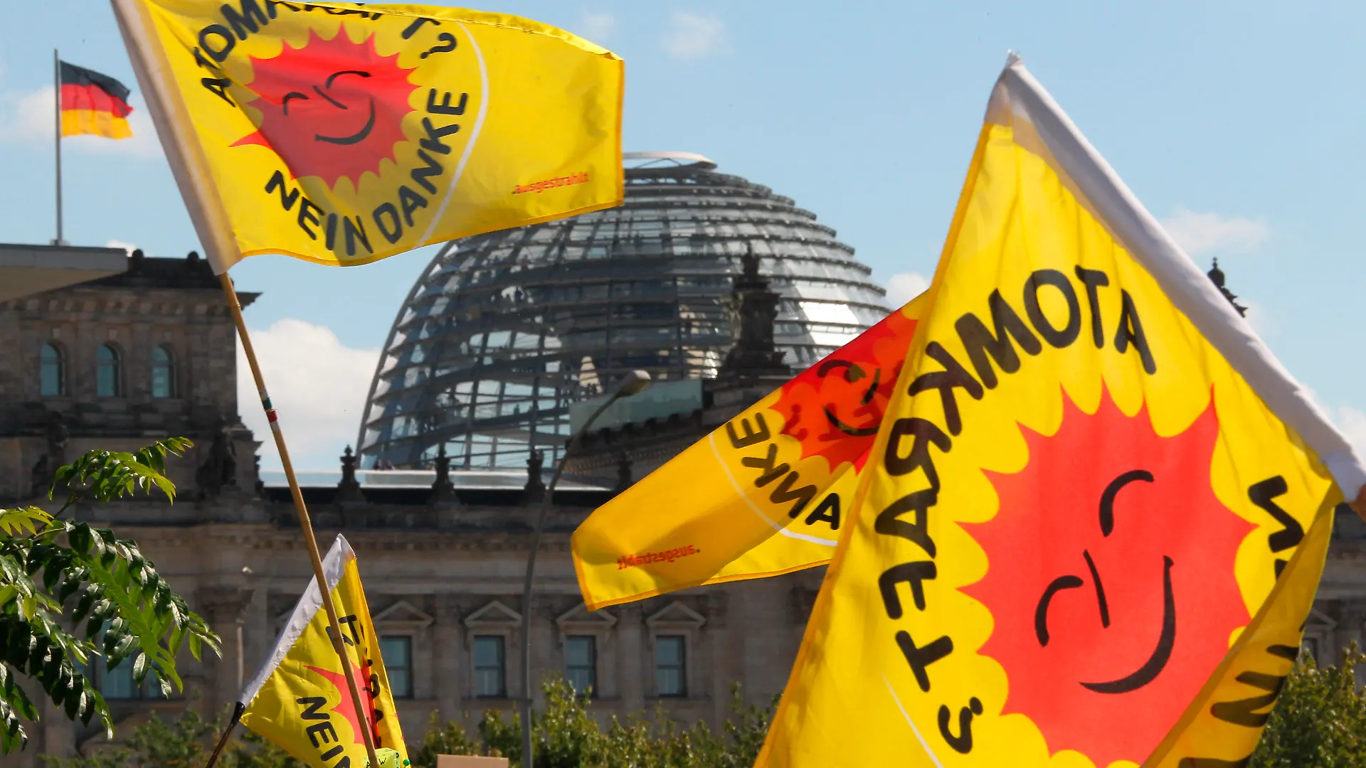 Fahnen von Atomkraft-Gegnern, die am Kanzleramt in Berlin gegen die Atompolitik der Bunderegierung demonstrieren, wehen am Sonntag (05.09.2010) vor der Kuppel des Reichstages. Die Spitzen der Koalition unter Leitung von Bundeskanzlerin Merkel treffen sich hier zu einem Gespräch über Energiepolitik. Thema des Treffens ist die Laufzeitverlängerung von Atomkraftwerken in Deutschland. Foto: Wolfgang Kumm dpa/lbn +++(c) dpa - Bildfunk+++