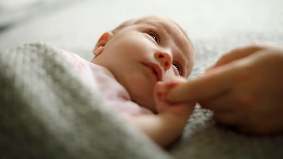 Newborn baby holding mother's hand