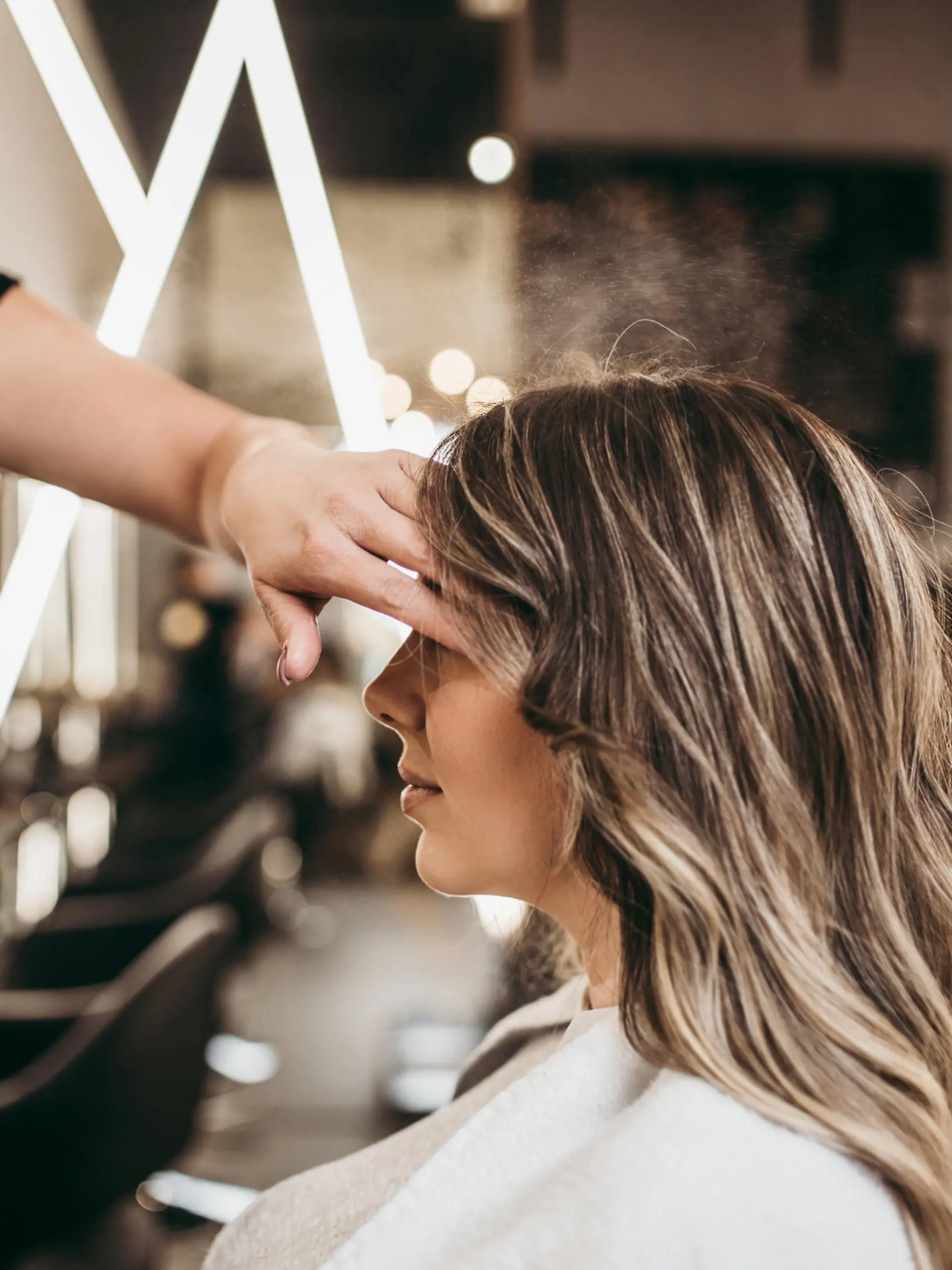 Beautiful brunette woman with long hair at the beauty salon getting a hair blowing. Hair salon styling concept.