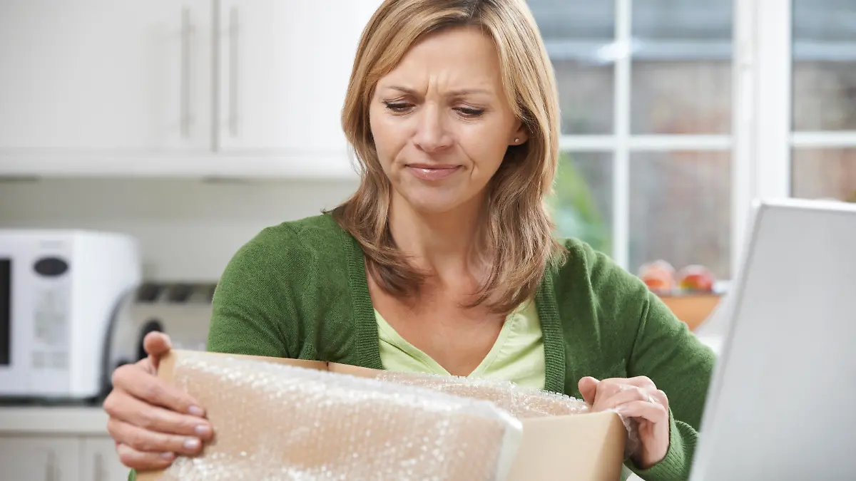 Frau öffnet Paket - Inhalt gefällt nicht