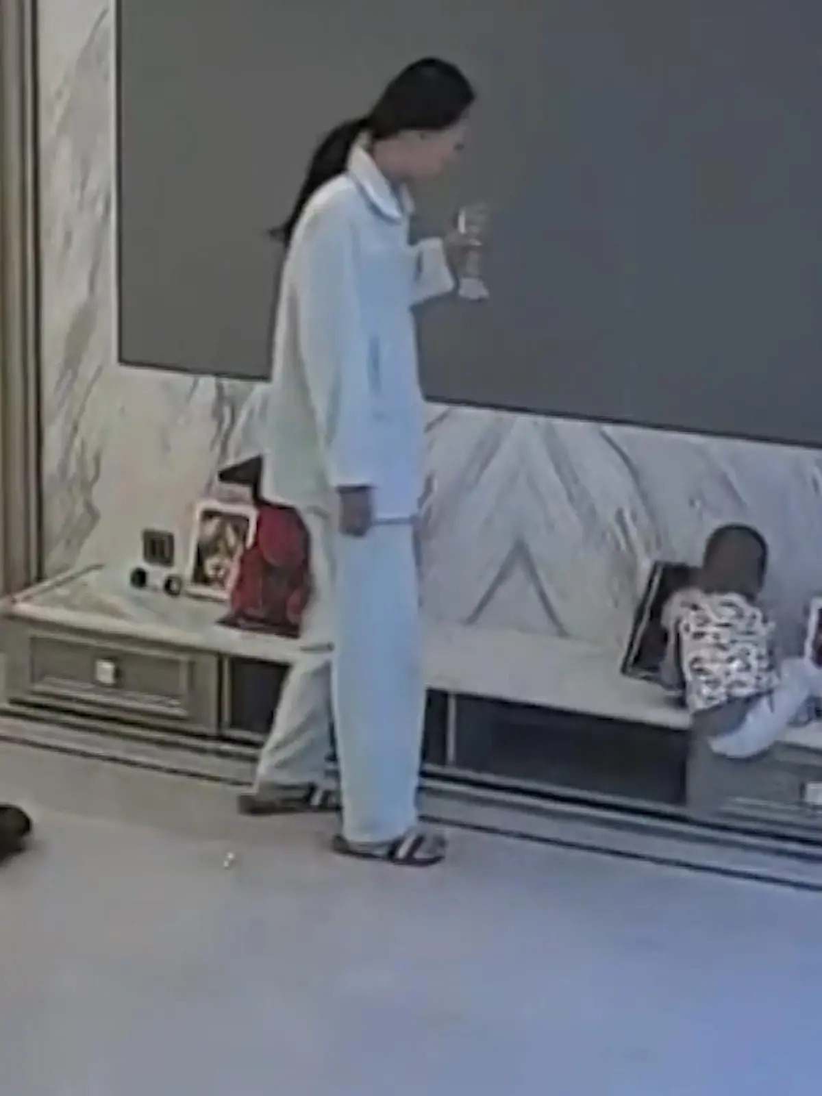 In diesem Wohnzimmer im Osten von China kommt es zu einem echten Mama-Moment: Schlaftrunken zieht Mama mit einem Getränk in der Hand durch die Wohnung, als sie ihr Kind auf einem Sideboard spielen sieht.