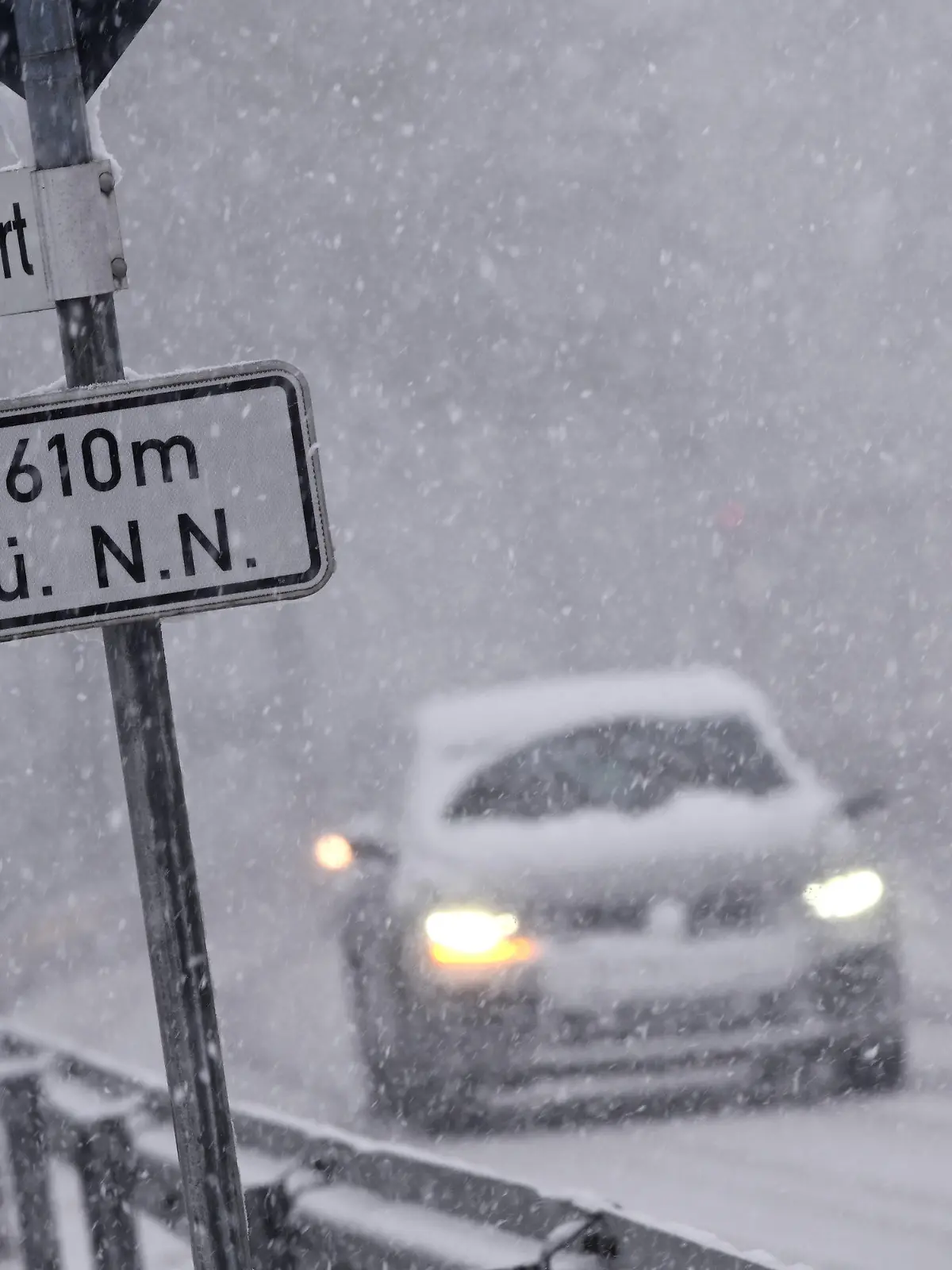 04.02.2020, Hessen, Willingen: Bei starkem Schneefall fahren Autos über eine Straße bei Willingen. Ein Schild weist eine Höhe von 610 Metern über Normal Null aus. Foto: Uwe Zucchi/dpa +++ dpa-Bildfunk +++