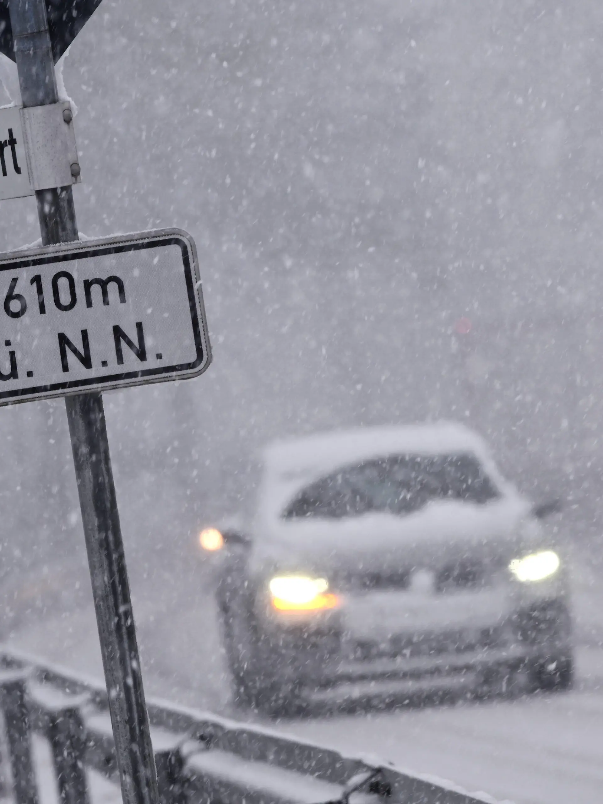 04.02.2020, Hessen, Willingen: Bei starkem Schneefall fahren Autos über eine Straße bei Willingen. Ein Schild weist eine Höhe von 610 Metern über Normal Null aus. Foto: Uwe Zucchi/dpa +++ dpa-Bildfunk +++