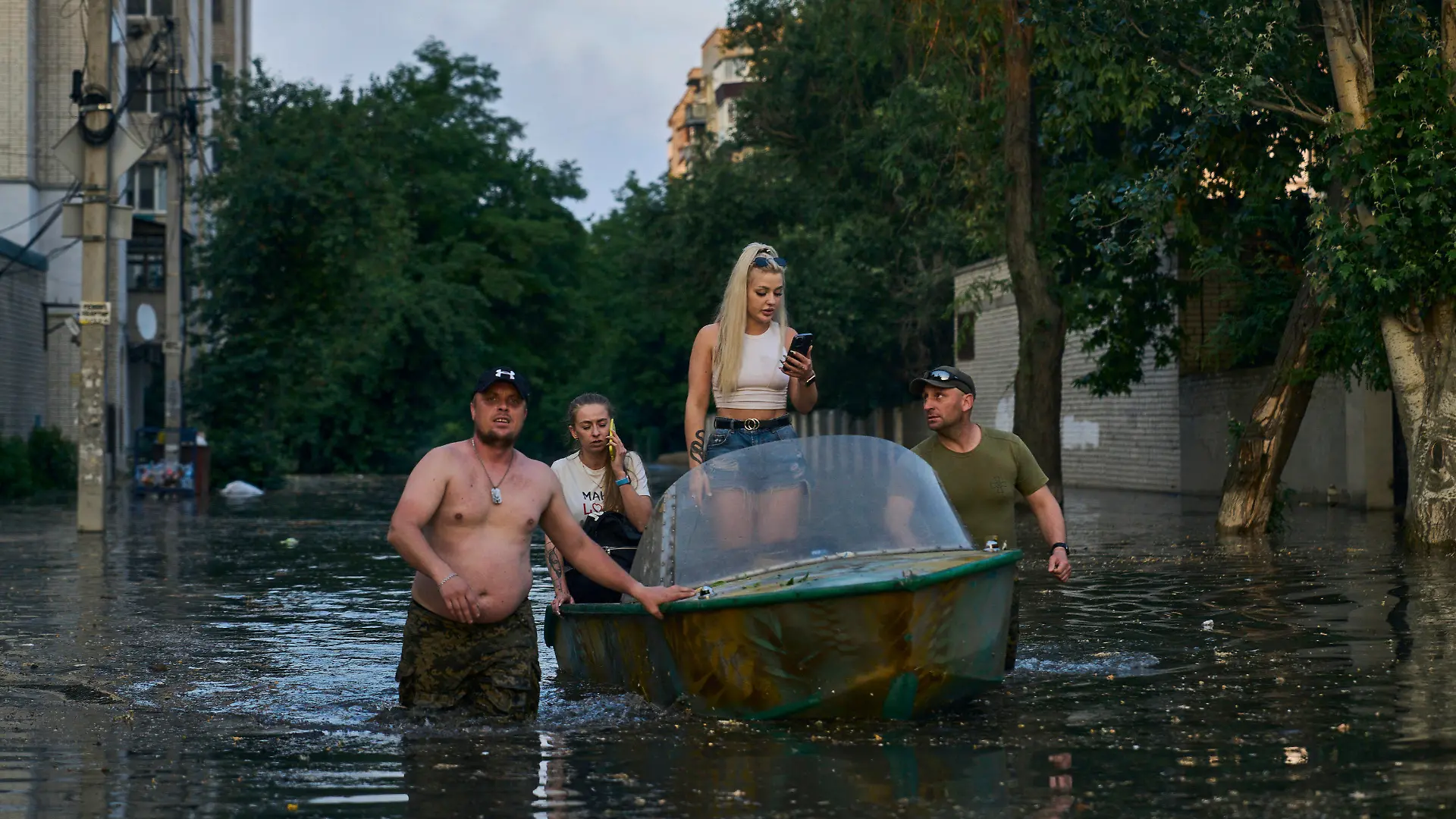 dpatopbilder - 06.06.2023, Ukraine, Cherson: Rettungskräfte transportieren Bewohner mit Booten, die aus einem überfluteten Viertel in Cherson evakuiert werden sollen. Der russische Angriffskrieg gegen die Ukraine ist durch die Sprengung des wichtigen Kachowka-Staudamms gefährlich eskaliert - mit noch unabsehbaren humanitären, ökologischen und militärischen Folgen. Foto: Libkos/AP/dpa +++ dpa-Bildfunk +++