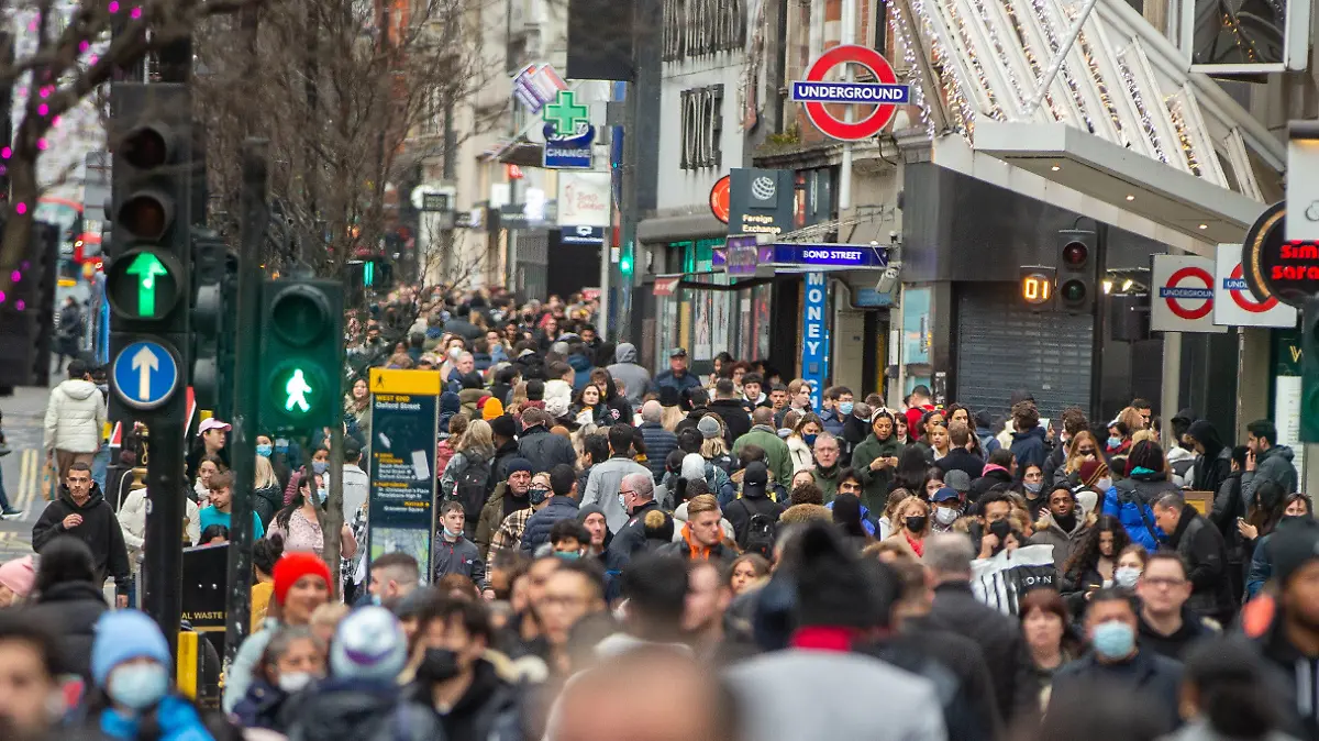28.12.2021, Großbritannien, London: Menschen laufen durch das Londoner West End. Trotz täglicher Neuinfektionen in Rekordhöhe über die Weihnachtstage will die britische Regierung vorerst keine strengeren Corona-Regeln im größten Landesteil England einführen. Foto: Tayfun Salci/ZUMA Press Wire/dpa +++ dpa-Bildfunk +++
