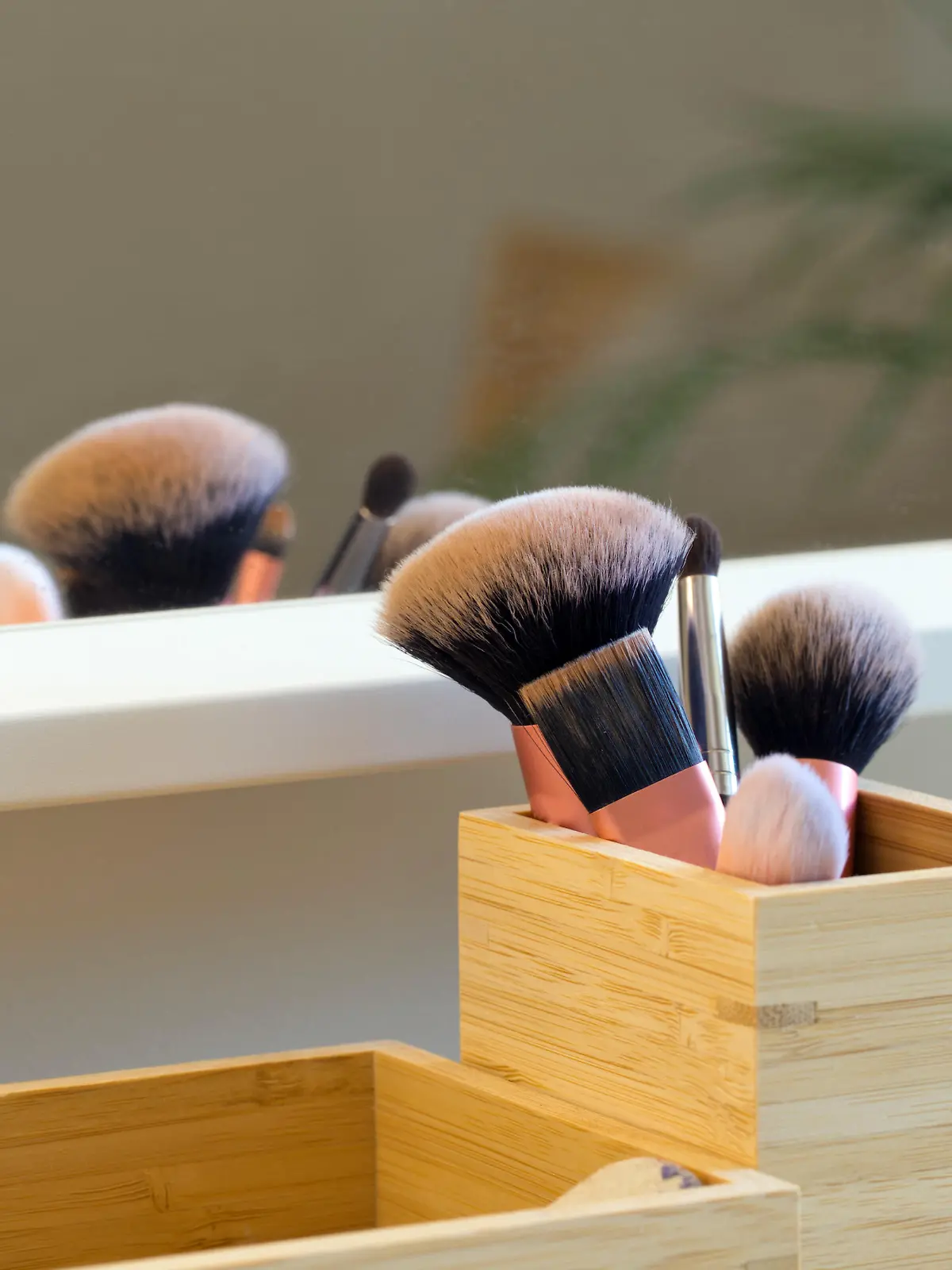 Professional makeup brush set on makeup table near mirror in wooden storage box close-up beauty concept