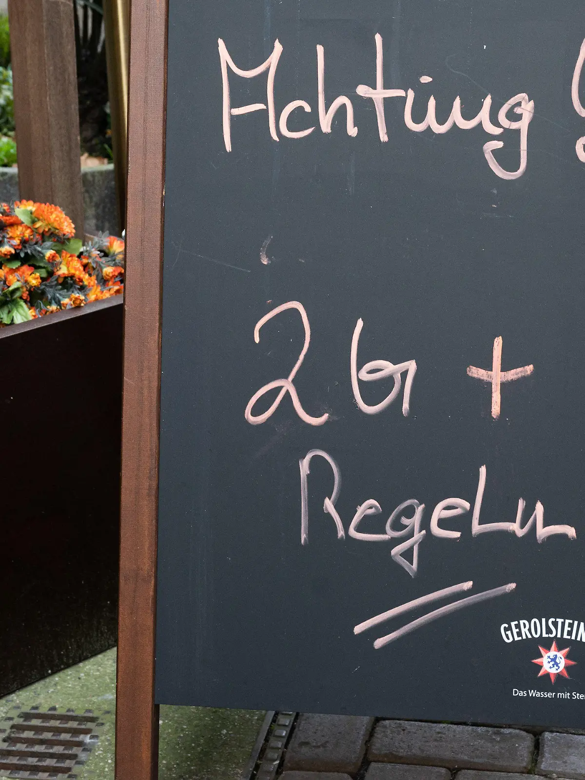 10.12.2021, Niedersachsen, Hannover: Ein Hinweisschild mit Aufschrift "Achtung! 2G+ Regel" steht vor einem Restaurant in der Innenstadt. Foto: Julian Stratenschulte/dpa +++ dpa-Bildfunk +++