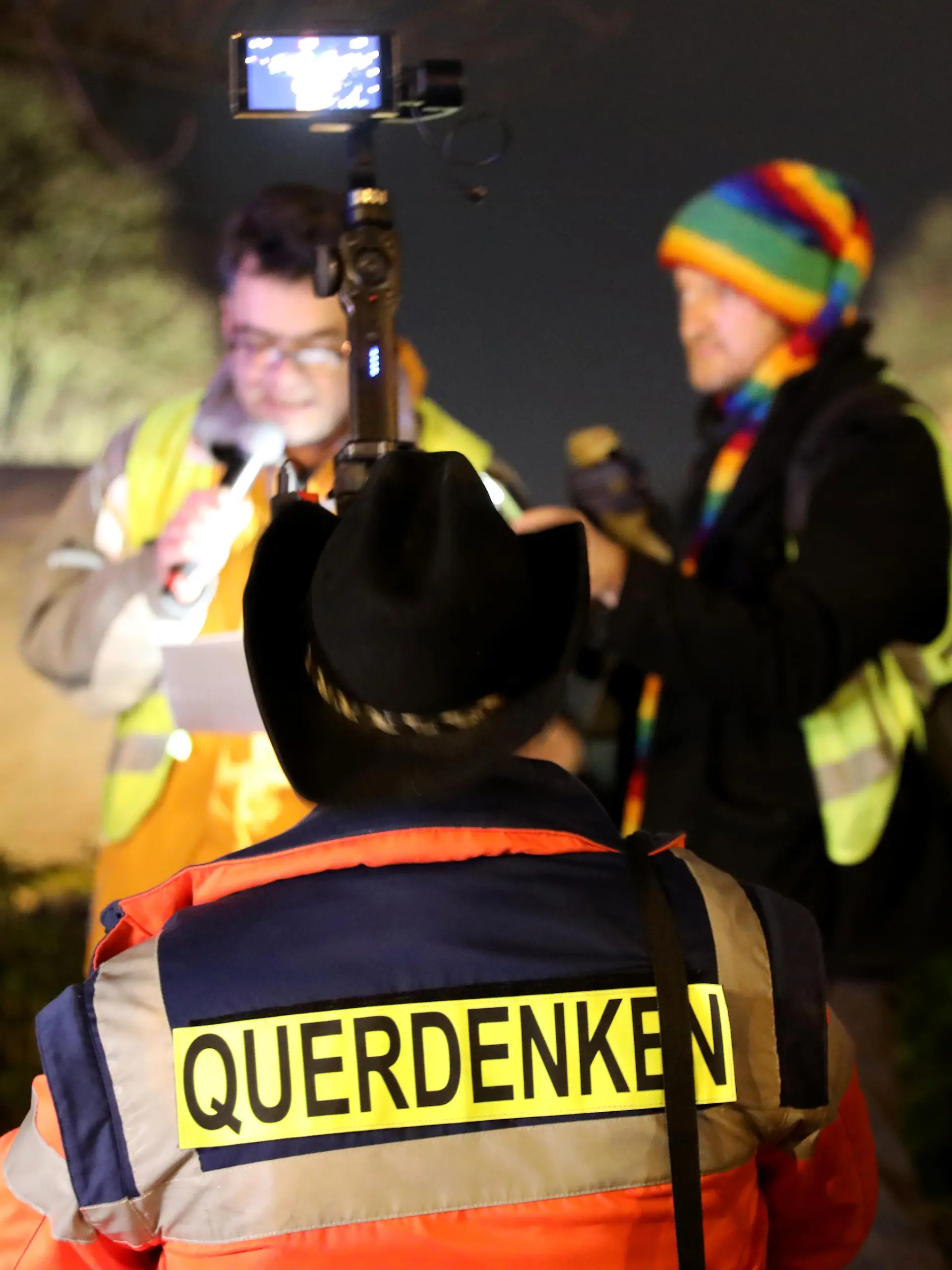 Das Wort «Querdenken» trägt ein Teilnehmer einer Demonstration gegen Corona-Maßnahmen auf dem Rücken während er den Organisatoren Jens Kaufmann (l) filmt. Auf dem Veranstaltungsgelände müssen die Demonstranten wegen des Coronavirus einen Mund-Nasenschutz tragen. Zudem gilt das Abstandsgebot. In mehreren Städten Deutschlands haben Menschen gegen die Corona-Maßnahmen demonstriert.