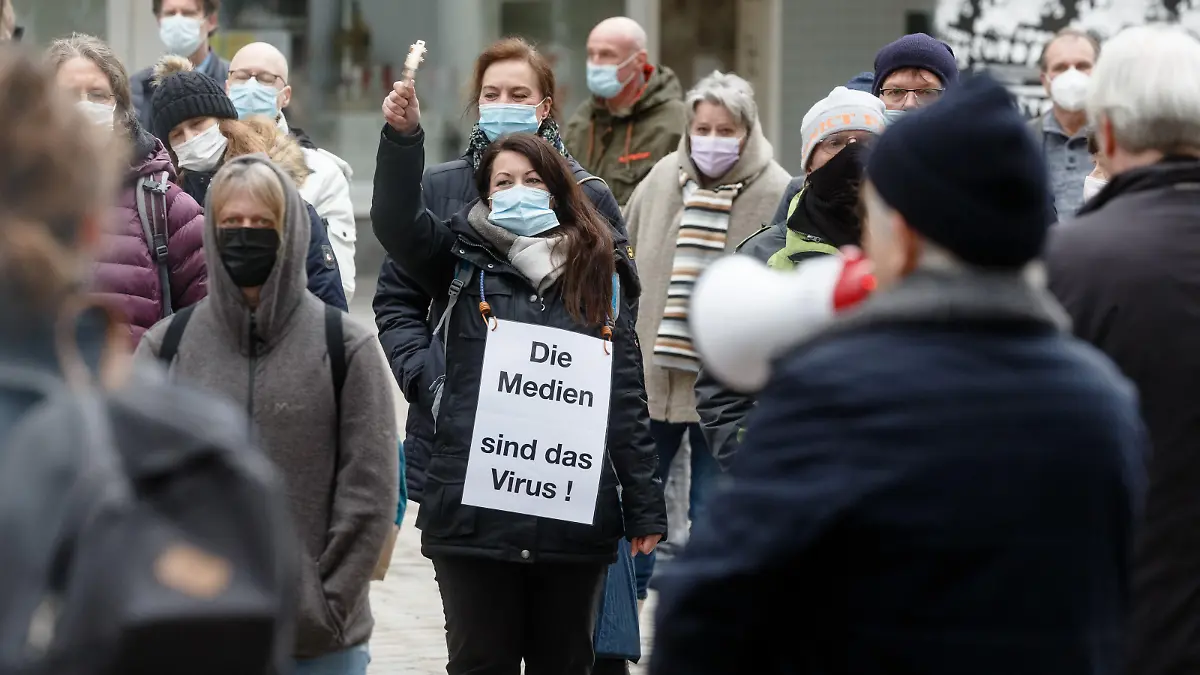 Eine Frau trägt auf einer Demonstration von Corona-Leugnern und Kritikern der staatlichen Massnahmen zur Eindämmung der Corona-Pandemie ein Schild mit der Aufschrift "Die Medien sind das Virus".