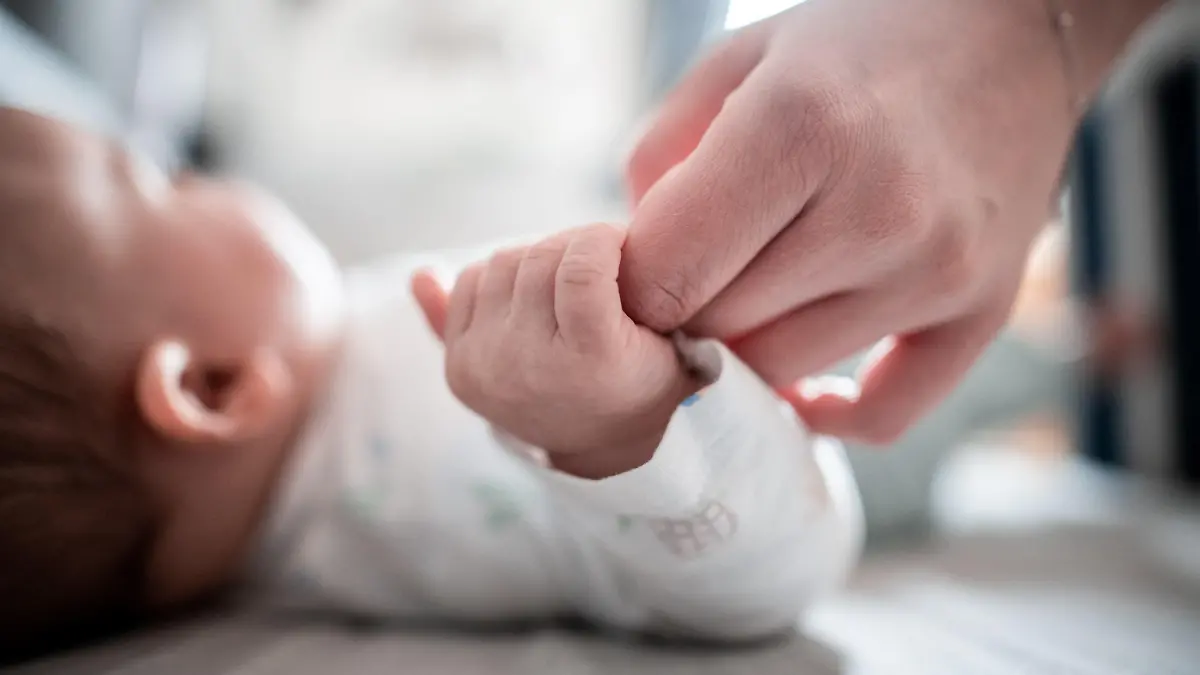 ARCHIV - 30.12.2019, Nordrhein-Westfalen, Oberhausen: Ein Baby klammert sich an den Finger seiner Mutter. In Bayern ist ein coronabedingter Babyboom mutmaßlich ausgeblieben. Die von den Standesämtern in über 30 bayerischen Kommunen gemeldeten Geburtsanzeigen für den Dezember und Januar deuten nicht auf einen großen Anstieg der Geburtenzahlen. Ausnahme ist München. Foto: Fabian Strauch/dpa +++ dpa-Bildfunk +++