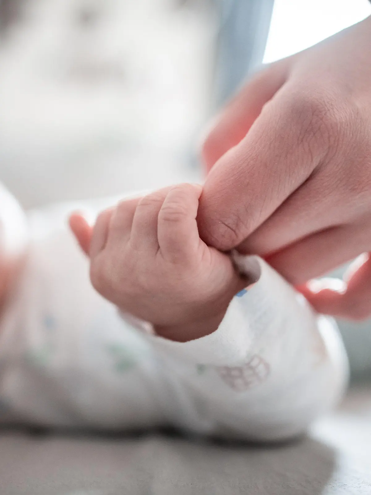 ARCHIV - 30.12.2019, Nordrhein-Westfalen, Oberhausen: Ein Baby klammert sich an den Finger seiner Mutter. In Bayern ist ein coronabedingter Babyboom mutmaßlich ausgeblieben. Die von den Standesämtern in über 30 bayerischen Kommunen gemeldeten Geburtsanzeigen für den Dezember und Januar deuten nicht auf einen großen Anstieg der Geburtenzahlen. Ausnahme ist München. Foto: Fabian Strauch/dpa +++ dpa-Bildfunk +++