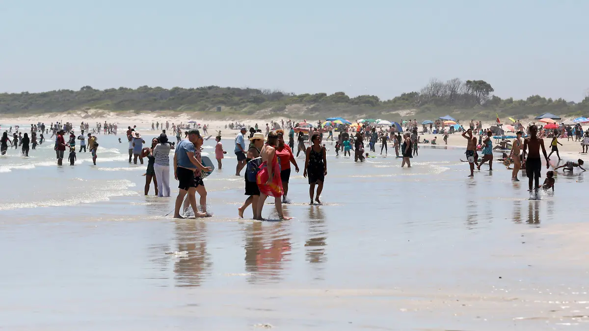 21.12.2021, Südafrika, Kapstadt: Urlauber genießen einen Tag am Strand in der Nähe von Kapstadt. Die Zahl der neuen Corona-Fälle geht in Südafrika in den letzten Tagen zurück. Foto: Nardus Engelbrecht/AP/dpa +++ dpa-Bildfunk +++