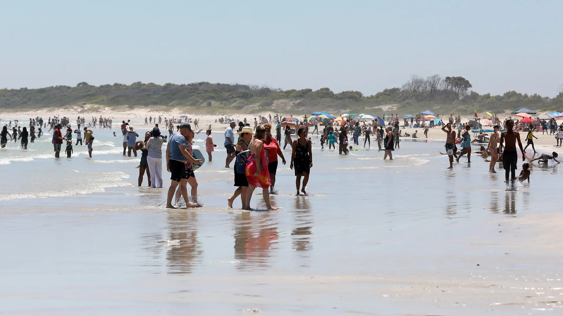 21.12.2021, Südafrika, Kapstadt: Urlauber genießen einen Tag am Strand in der Nähe von Kapstadt. Die Zahl der neuen Corona-Fälle geht in Südafrika in den letzten Tagen zurück. Foto: Nardus Engelbrecht/AP/dpa +++ dpa-Bildfunk +++