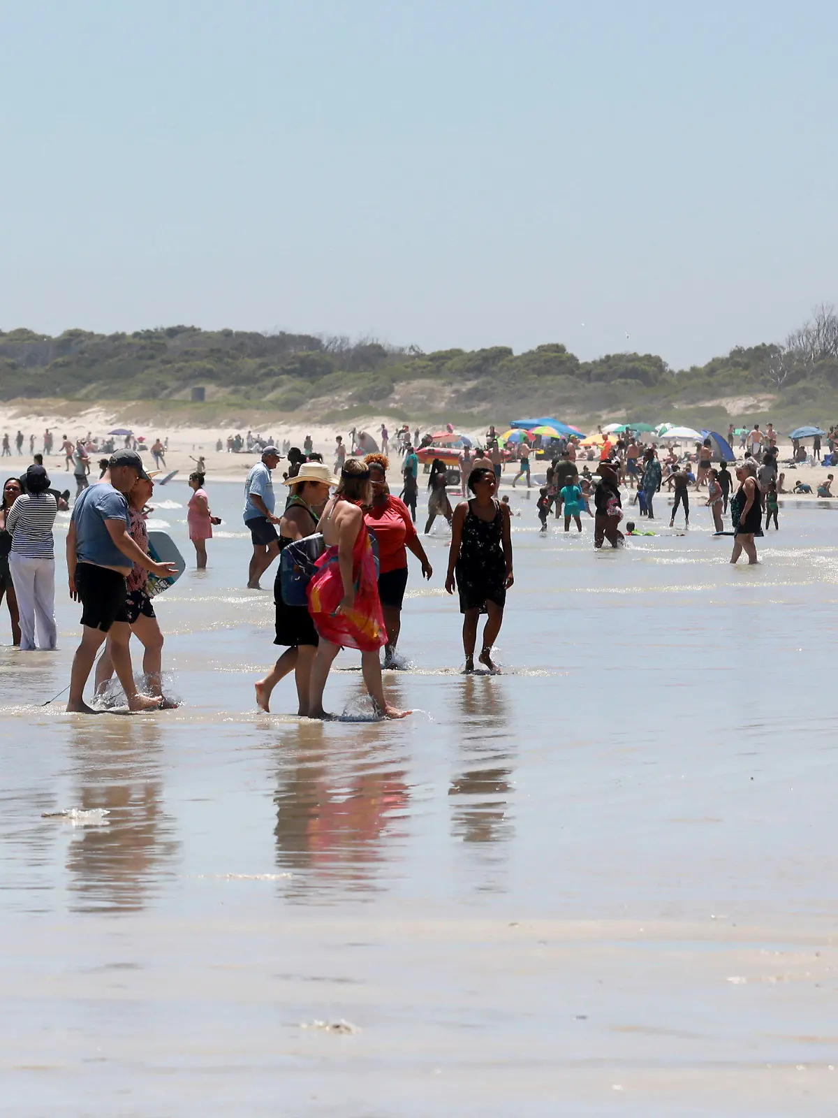 21.12.2021, Südafrika, Kapstadt: Urlauber genießen einen Tag am Strand in der Nähe von Kapstadt. Die Zahl der neuen Corona-Fälle geht in Südafrika in den letzten Tagen zurück. Foto: Nardus Engelbrecht/AP/dpa +++ dpa-Bildfunk +++