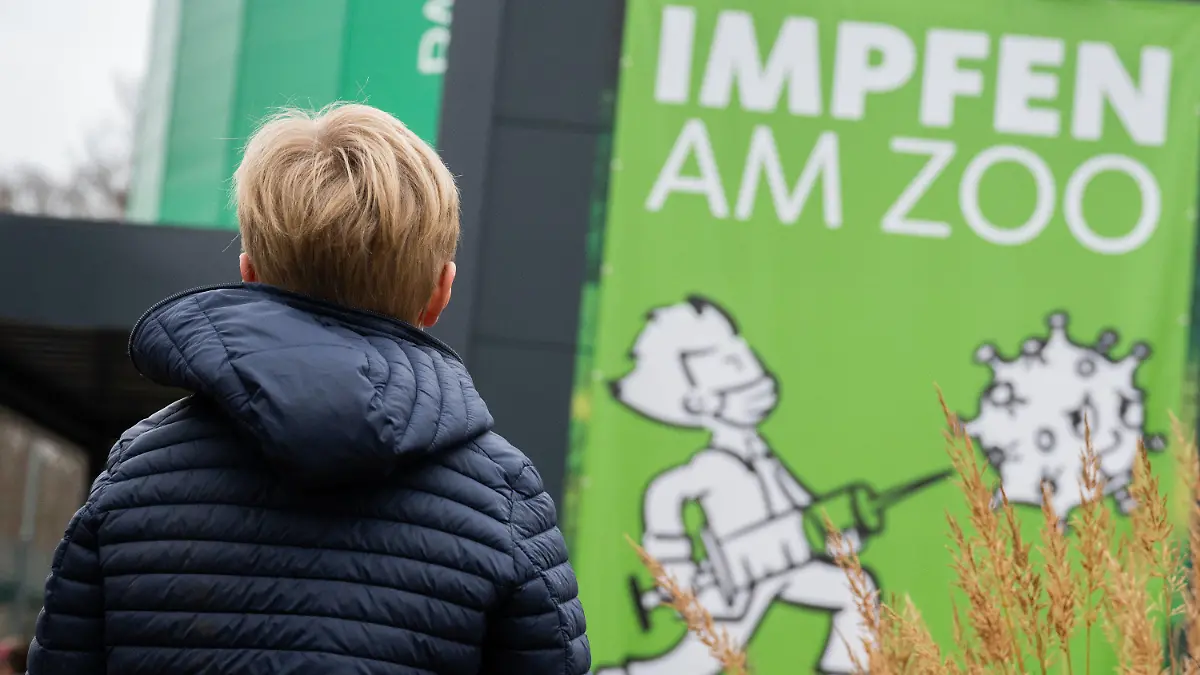 15.12.2021, Niedersachsen, Hannover: Ein 8-jähriger Junge steht am Impfzentrum am Zoo im früheren Regenwald-Panorama des Erlebnis-Zoo Hannover. In Niedersachsen starten an diesem Mittwoch die Corona-Impfungen für Fünf- bis Elfjährige. Der Impfstoff von Biontech/Pfizer ist seit kurzem auch für Kinder ab fünf Jahren zugelassen. Foto: Julian Stratenschulte/dpa +++ dpa-Bildfunk +++