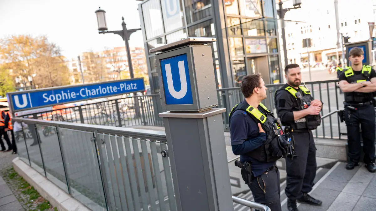 12.04.2025, Berlin: Berliner Polizisten stehen nach einer Gewalttat vor dem U-Bahn Eingang Sophie-Charlotte-Platz. Ein Angreifer hat einen Mann bei einer Auseinandersetzung in einem Berliner U-Bahnhof erstochen und tödlich verletzt. Die Polizei habe danach auf den Angreifer schießen müssen. Foto: Fabian Sommer/dpa +++ dpa-Bildfunk +++