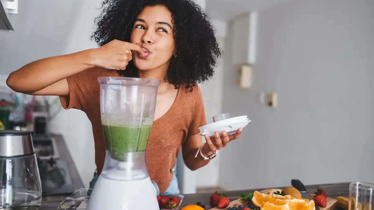 Shot of a young woman making a healthy smoothie at home