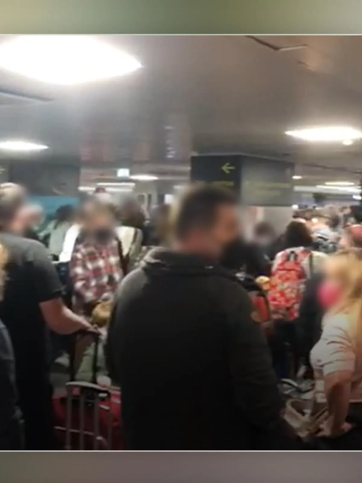 Viele Menschen stehen dicht gedrängt im Terminal eines Flughafens