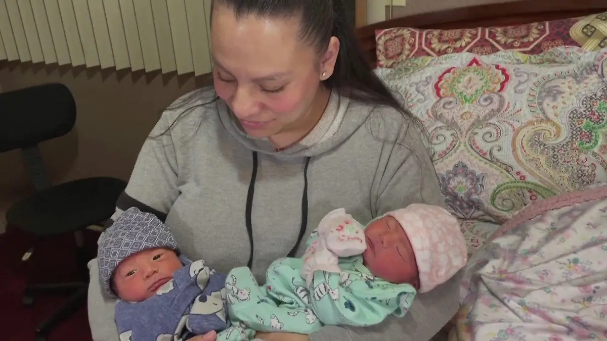 Mama hält ihre Zwillinge im Arm.