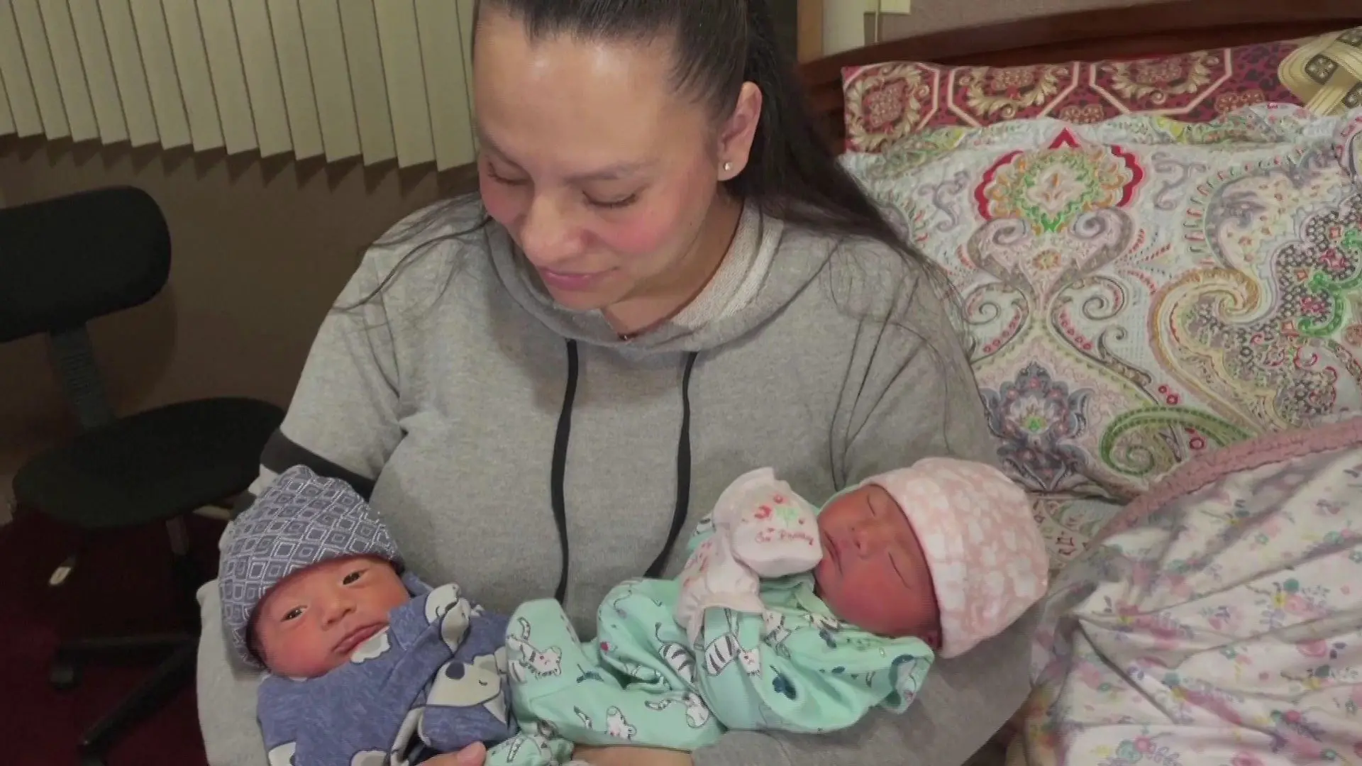 Mama hält ihre Zwillinge im Arm.