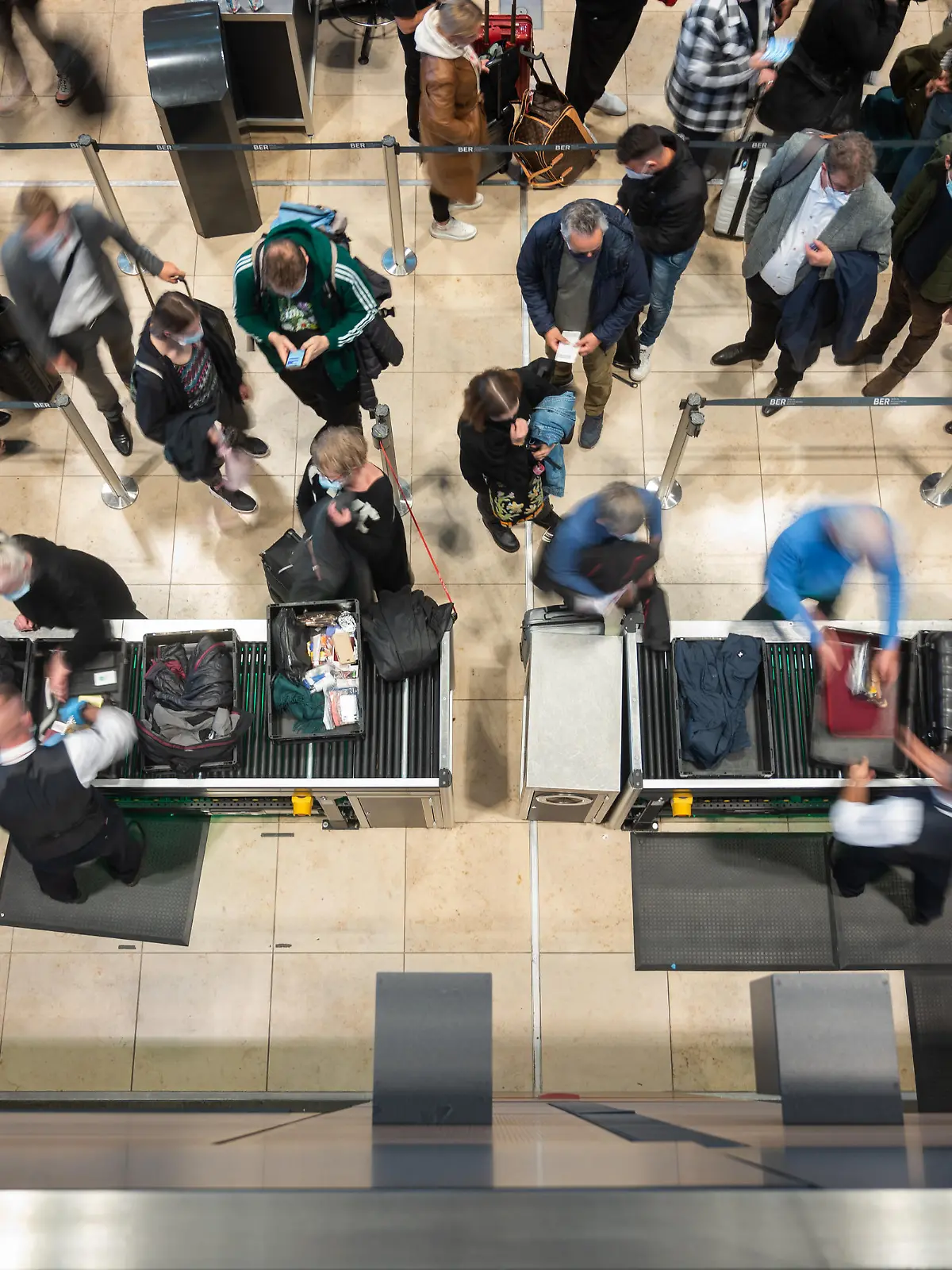 Passagiere stehen an einer Sicherheitskontrolle in Schlangen. Nach einem Feueralarm am Flughafen BER wurde der Sicherheitsbereich geräumt und die Fluggäste mussten ein zweites mal durch die Sicherheitskontrolle.