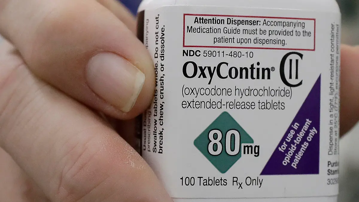 ARCHIV - 02.04.2018, USA, San Francisco: Ein Apotheker hält eine Flasche mit Oxycontin des US-Pharmakonzerns Purdue. Opioide wie Oxycontin sind Arzneimittel mit unter schmerzlindernden Eigenschaften, bei denen jedoch auch enorme Abhängigkeitsrisiken und hohes Missbrauchspotenzial bestehen. (Zu dpa "Opioid-Klagen: Gericht kippt Milliardenvergleich mit Purdue Pharma") Foto: Jeff Chiu/AP/dpa +++ dpa-Bildfunk +++