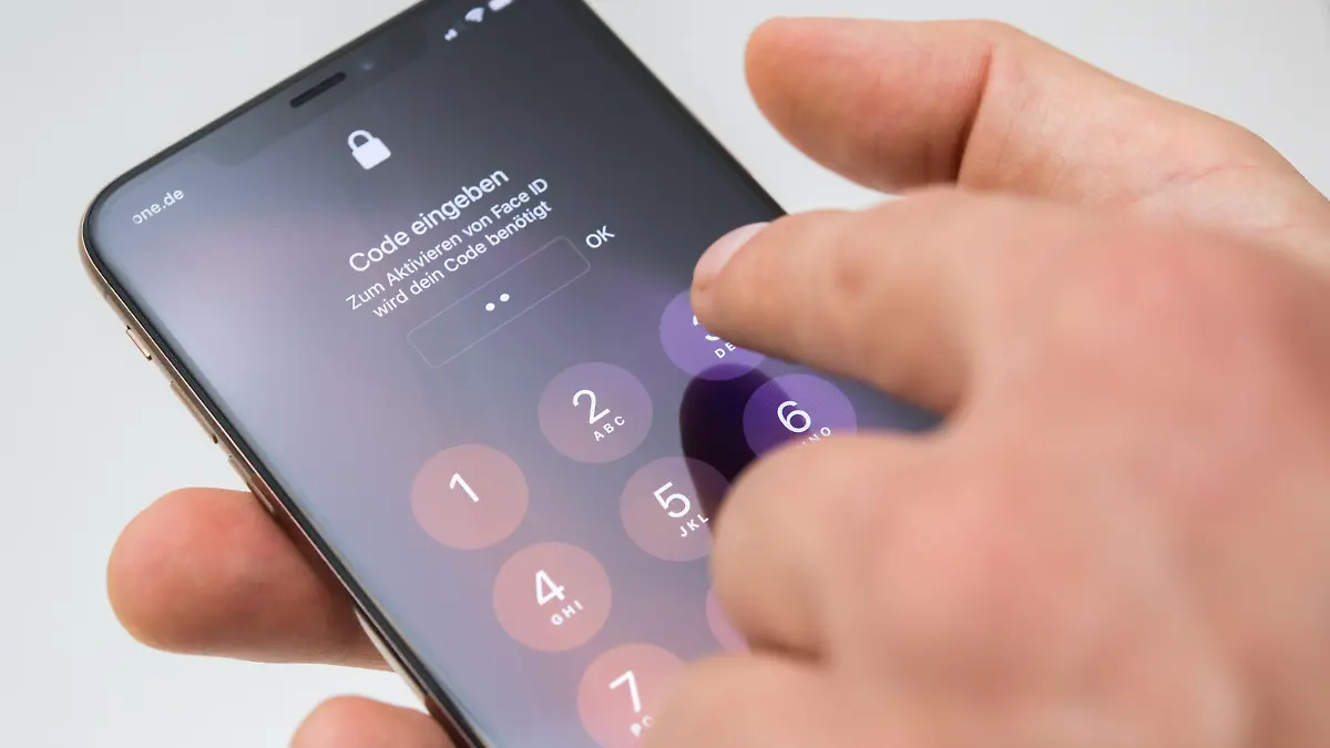 ILLUSTRATION - Ein Mann entsperrt am 17.09.2018 in Berlin das iPhone XS MAX mit einem Code (gestellte Szene). Foto: Andrea Warnecke