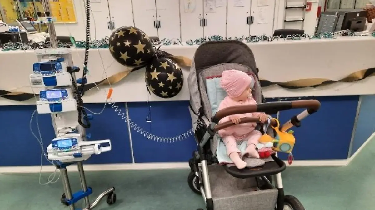 Ida sitzt in ihrem Kinderwagen. Neben ihr stehen die Geräte.