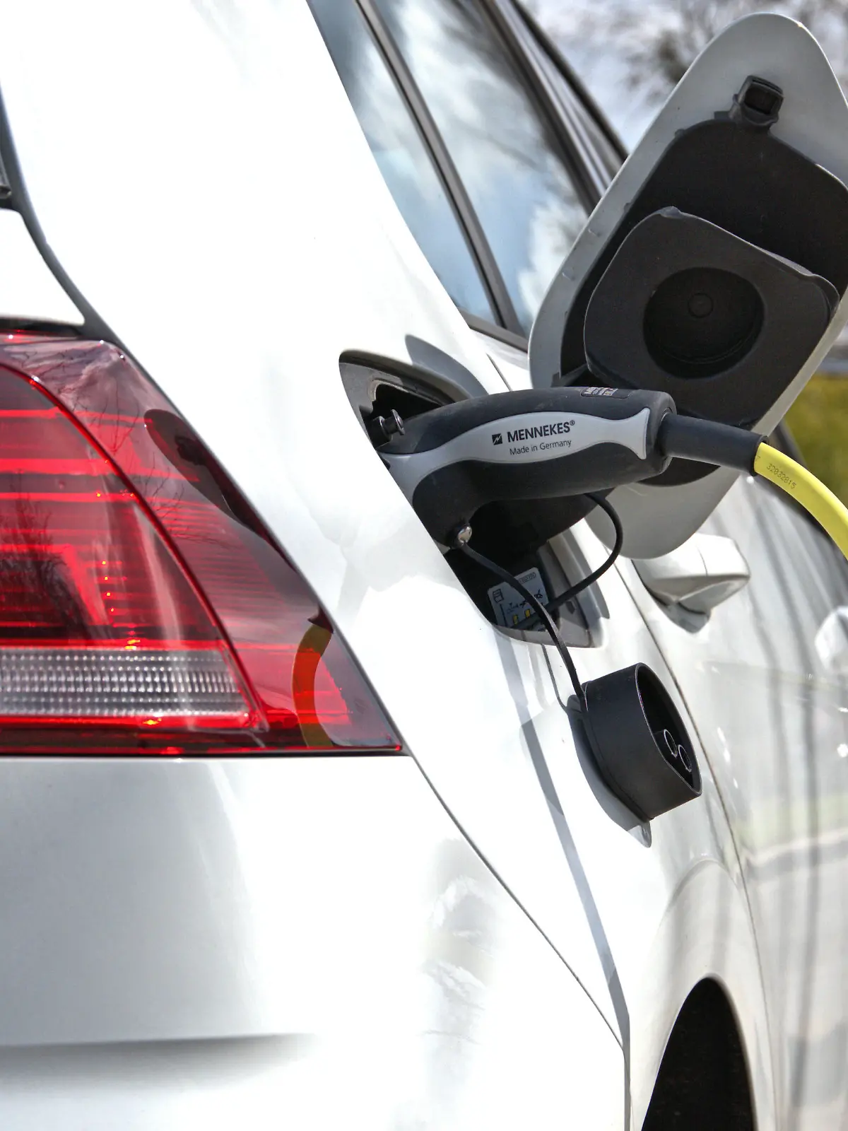 Schleswig, ein Mennekes Ladestecker in einem weißen, elektrischen Golf auf einem E-Parkplatz in der Friedrich-Ebert-Straße.