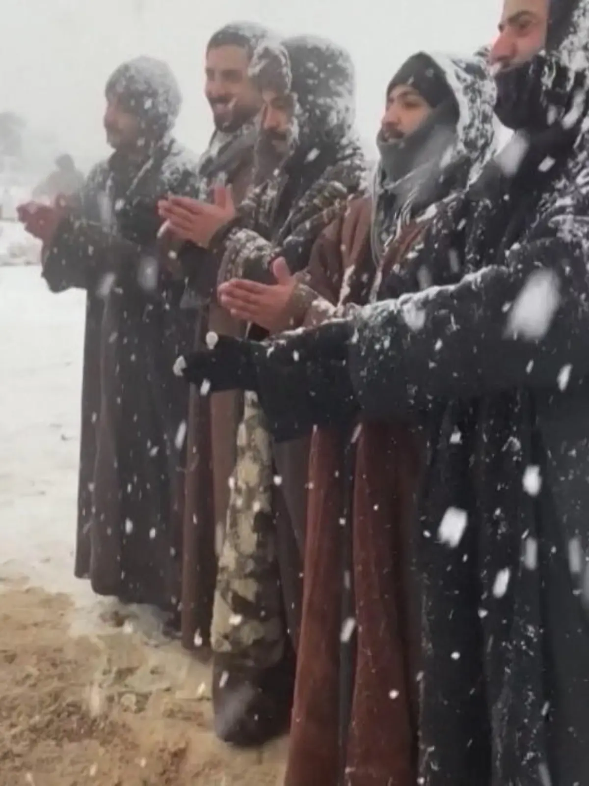 Mit einem traditionellen „Dabke“-Reihentanz zelebriert eine Gruppe arabischer Männer den seltenen Moment, als es zu Schneefall in ihrer Heimat Tabuk in Saudi-Arabien kommt.