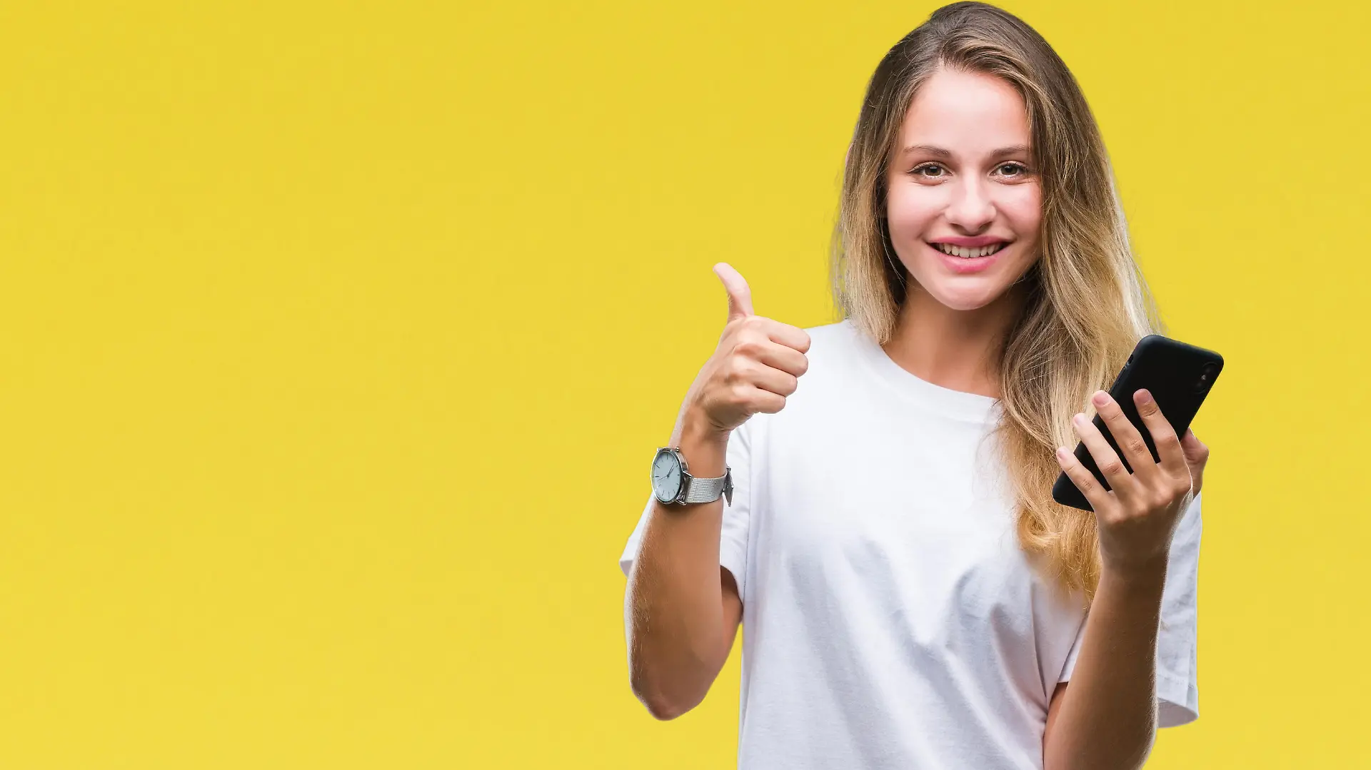 Young beautiful blonde woman using smartphone over isolated background happy with big smile doing ok sign, thumb up with fingers, excellent sign